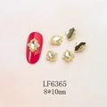 Close-up of golden nail art charm with rhombus crystal and micro-pave details - Gold Base Transparent Marquise (6365)