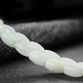Pale green jadeite bracelet with oval beads showcasing a glossy polished finish - Jade Color