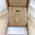 Detailaufnahme des goldenen Kleeblatt-Anhängers mit Herz-Zirkon in einer Schmuckschatulle - Titanstahlkette Kupferanhänger / Kleeblatt Herz Anhänger Halskette (E401)