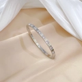 Macro detail of silver titanium steel bracelet featuring square-cut sparkling zirconia - Silver