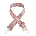 Close-up of pink nylon bag strap with white arrow pattern and gold metal hardware - Pink
