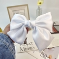 Detail of a large white satin bow hair clip with elegant silk texture and glossy finish - White (Spring Clip)