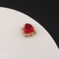 Detailed close-up of a gold-plated heart pendant with a large red zircon and white rhinestones - Red