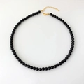 Detailed top view of black onyx beaded necklace with a golden lobster clasp and chain - 6mm Round Bead Necklace