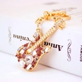 Creative gold metal guitar keychain featuring purple and white sparkling rhinestones - Purple