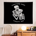Modern black wall tapestry featuring two skeletons hugging with artistic text - Everything Sucks Skeleton