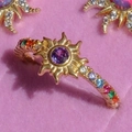 Macro shot of gold solar ring with purple stone and colorful zircon pavé on pink velvet - Colorful Open Ring / Gold/Multicolor