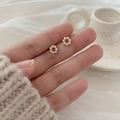 Close-up of elegant gold flower stud earrings with white pearls shown on fingertips - Gold Circle Wreath (30# Silver Earring Post)