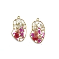 Detailed close-up of face silhouette resin charms with colorful dried flowers in gold frames - Rose Red Face