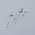 Detail of silver long drop earrings with a row of sparkling tassels on a grey background - White Gold