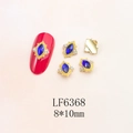 Detail of dark blue marquise crystal nail art charm with tiny diamonds on red nails - Gold Base Dark Blue Marquise (6368)