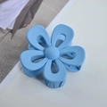 Macro shot of the blue matte flower hair claw clip with its durable grip teeth design - Blue