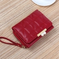 Elegant red quilted short wallet with pearl clasp and wristlet strap on a wood surface - Dark Red
