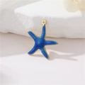 Vue macro d'un pendentif étoile de mer bleu foncé avec bord doré et texture émaillée - Bleu