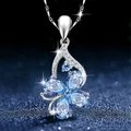 Silver butterfly necklace with blue teardrop crystals and small zircon accents on blue background - Four Leaf Clover [Blue Clover Pendant - No Chain]