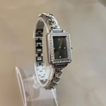 Detail of silver rectangle watch with rhinestone bezel on acrylic stand display - Black