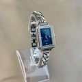 Nahaufnahme der Damenuhr mit blauem Zifferblatt, Strasslünette und silbernem Gliederarmband - Marineblau