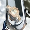 Dettaglio dell'orologio quadrato verde con lunetta di diamanti e cinturino bicolore - Bicolore Quadrante Bianco