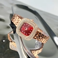 Dettaglio orologio quadrato in oro rosa con quadrante rosso e diamanti su superficie riflettente - Oro Rosa Quadrante Rosso