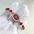Detail view of oval gold watch with red dial and crystal leaf-shaped bracelet - Red Oval