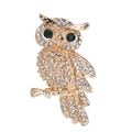 Elegant owl brooch with sparkling rhinestones and green gem eyes on golden branch - Gold White