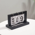 Minimalist black wooden perpetual flip calendar on table with soft plant shadows - Black