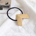 Chic gold geometric arrow metal hair tie with black elastic band on white fabric - Metal / Geometric Gold