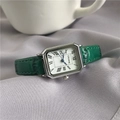 Detail view of a vintage square watch with green leather strap on silk fabric - Silver Case Green Strap