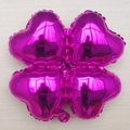 Magenta clover shaped foil balloon with metallic finish on light wood floor background - Rose Red