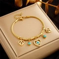 Gold-toned evil eye charm bracelet with heart pendants on a satin jewelry box display - Evil Eye Heart Pendant Style (B788) / Gold