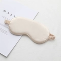 Champagne silk sleep mask with elastic strap shown on a magazine background - Apricot