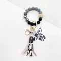 Detail of cow print tassel, wood beads, and butterfly charm with mama text engraving - Gray