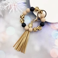 Detailed close-up of leopard print silicone beads with gold tassel on a wristlet keychain - Khaki