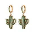 Golden cactus drop earrings featuring emerald green cubic zirconia stones on white background - Green Cactus Style