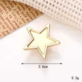 Macro di un ciondolo a stella dorata da 2,6 cm su sfondo di tessuto bianco - C233 26mm Stella