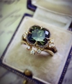 Detailed macro of a gold emerald ring featuring green gemstones in a blue velvet box - Cy738 / Size 5