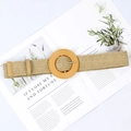 Close-up of beige woven straw elastic belt with circular wood grain buckle on a magazine - Big Round Buckle Khaki
