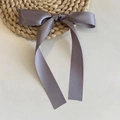 Detail of grey-purple satin ribbon bow hair clip with long streamers on woven mat - Duckbill Hair Clips / Short/PC / Gray