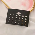 Set of 12 pairs of fashion pearl and metal stud earrings on a black display card - 12 Pairs Pearl Style