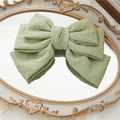Pasador de pelo con lazo verde plisado de tres capas sobre un espejo vintage - Verde