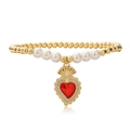 Dettaglio macro di un ciondolo a cuore dorato con pietra rossa su bracciale di perle - Stile Corona Sacro Cuore Oro (2070YH)