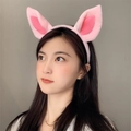 Cute pink plush pig ear headband for cosplay and travel photography worn by a female model - Pink Pig Ears