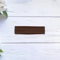 Detail of high-elasticity dark brown yoga headband on a natural white wood background - Coffee