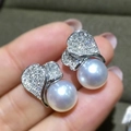 Elegant heart-shaped pearl earrings with sparkling zircon accents shown in a close-up view - White Gold