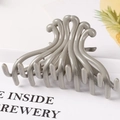 Detail shot of a grey wave-shaped glossy hair claw clip with interlocking teeth on a white desk - 10.5CM Large / Gray