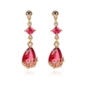 Detail view of 18K gold teardrop earrings featuring faceted red crystal and floral filigree - Red