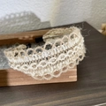 Primer plano de diadema de lino tejida a mano con patrones de ondas huecas en beige - A Bloque de Color Encaje Lino