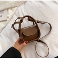 Detailed macro view of a dark brown mini crossbody bag held in hand for scale - Brown