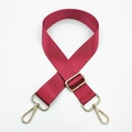 Close-up of adjustable wine red nylon bag strap with polished gold metal hardware - Burgundy