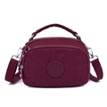 Dark red women's nylon crossbody bag with top handle and multiple zippers on white background - Dark Red